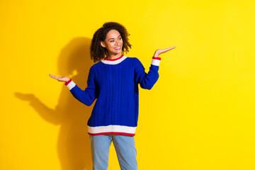 Young woman in stylish casual attire posing against a vibrant yellow background showcasing cheerful...