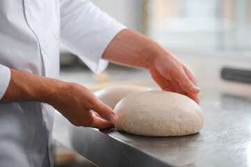baker making bread , man hands , kneading a dough , cooking coat