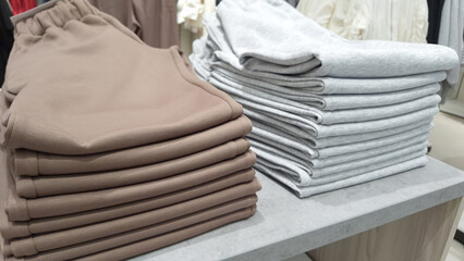 Neatly folded brown and gray sweatpants in retail store display