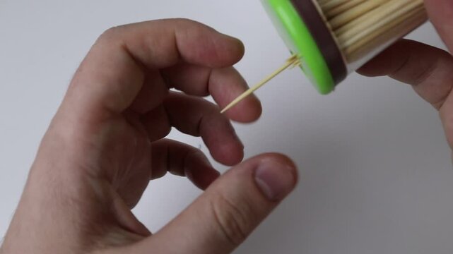 Male hands on white background take one toothpick from the jar
