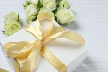 Beautiful white roses with gift box on white background