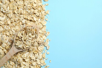 Composition with oatmeal flakes on blue background. Cooking breakfast