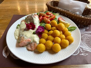 A delicious dish of grilled salmon, potato balls and vegetables on the table in a restaurant