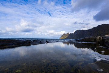 Autumn landscape of Senja Island in Northern Norway with colorful foliage, mountains, and a serene fjord.