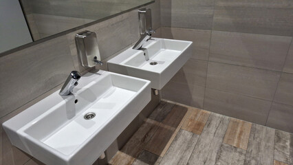 Modern bathroom with twin sinks and soap dispensers in minimalist design