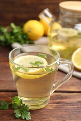 Healthy parsley tea with lemon slices on wooden table. Detox drink