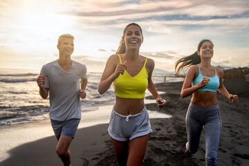 Portrait of a happy group of people exercising and doing sports and workout on the beach