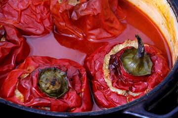 Stuffed bell peppers with meat and rice in tomato sauce, and spicy seasoning. homemade vegetarian dinner - baked colorful paprika stuffed with rice