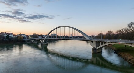 Naklejka premium Arch Bridge Over River at Sunset