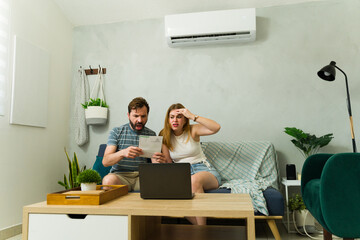 Couple worried about expensive electricity bill using air conditioning at home