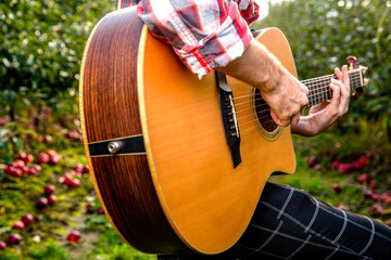 Close up of a hand, a man plays guitar. Man plays the guitar on the street retro style. Guitars...
