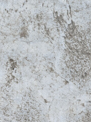 Close-up of a rough and weathered concrete surface with cracks and imperfections