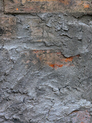 Close-up of an aged and weathered brick wall with concrete and mortar.