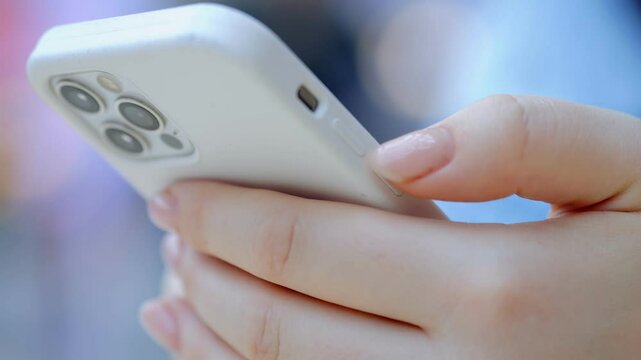 Person is holding a white iPhone with a case on it. The person is looking at the screen and he is texting