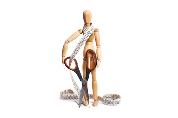 A wooden mannequin toy holding scissors and a measuring tape on white background