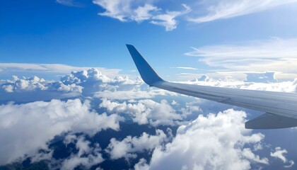 Airplane wing above fluffy clouds against a vibrant blue sky. Perfect for travel, adventure, and freedom themes.