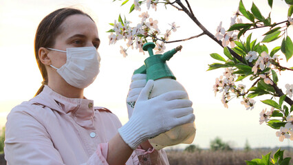 A gardener prepares to spray a blossoming tree with care, ensuring healthy growth in a vibrant...