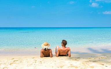Couple enjoying tranquility on a serene beach under the blue sky