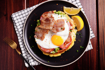 Fried Egg and Pork Waffles Food in a black plate on a wooden table
