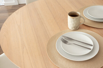Neutral table setting with coffee mug on wooden table in dinning room, close-up