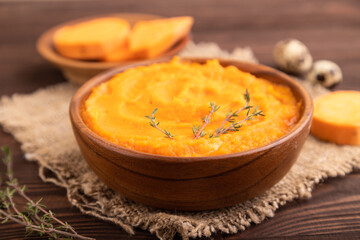 Sweet potato porridge in wooden bowl on wooden background. Diet, healthy eating. side view, selective focus