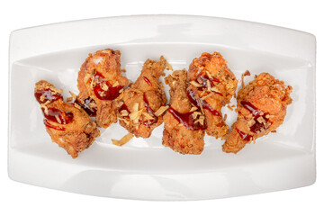 Deep fried chicken drumsticks on a plate isolated on a white background