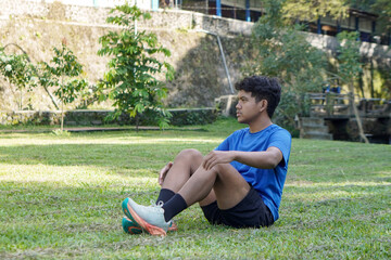 Fototapeta premium Portrait of Asian man in city park after jogging