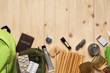 Survival kit. Different emergency supplies on wooden table, flat lay. Space for text