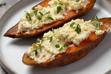Baked sweet potatoes with ricotta and fresh herbs. Healthy and vegan food