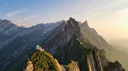 Adventurers take in stunning sunset view from mountain peak in Swiss Alps