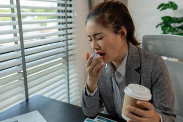 a female employee is feeling very stressed and tired form work, a businesswoman shows signs of...