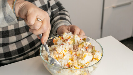 Caucasian woman mixing colorful vegetable salad, healthy eating, wellness, nutritious cooking, New Year's healthy resolutions