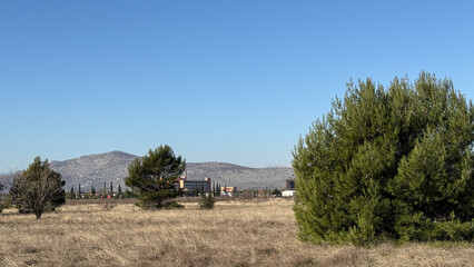 Expansive rural landscape with distant mountains under clear blue sky, ideal for Earth Day and...