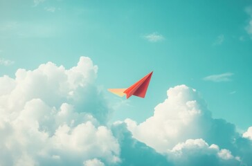Naklejka premium Minimalist close-up of a colorful paper airplane drifting through soft cottony clouds in a calm blue sky