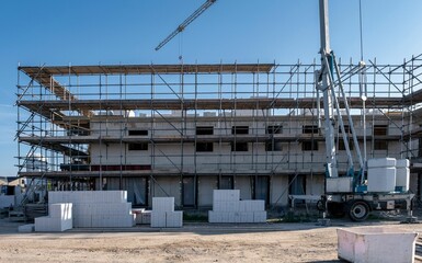 Modern family homes under construction in a Dutch suburban area with impressive scaffolding