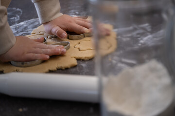 Child cutting out cookie shapes with metal cutters