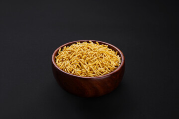 Indian popular snacks called Sev or Medium Sev isolated on black background 