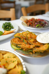 Assorted Turkish Meze Plates with Fried Zucchini, Liver, Potatoes and Yogurt Dip on a Restaurant Table