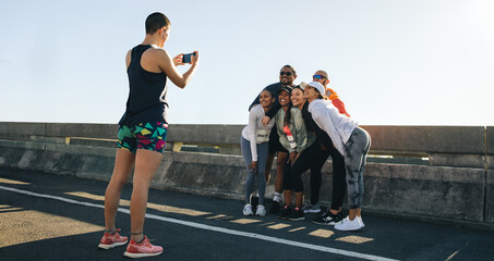 Group of cheerful runners posing for a photo during a marathon