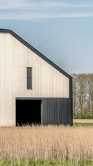 Modern architecture of a barn against a clear sky in a rural landscape