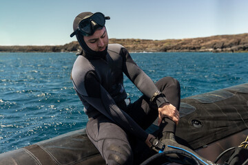 Scuba Diver Putting on Fins and Checking Gear on Boat