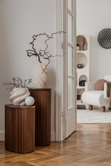 Pair of fluted wood pedestals with organic vases and natural branches in a bright hallway. © FollowTheFlow