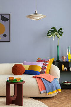 Interior desgin of modern living room interior with mock up poster frame, colorful decorations and accessories, plants, sofa, coffee table. Blue wall. Home decor. Template.