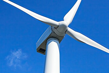Close-up of a wind turbine's nacelle and blades against a clear blue sky  White turbine components are sharply detailed