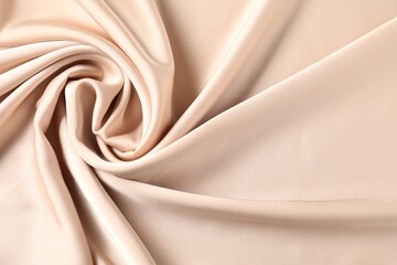 Beige crumpled silk fabric as background, top view