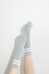 Woman in grey socks on light background, closeup