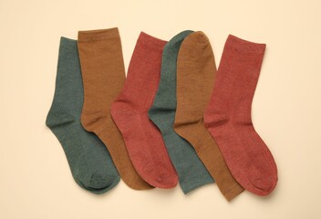 Many different pairs of socks on beige background, flat lay