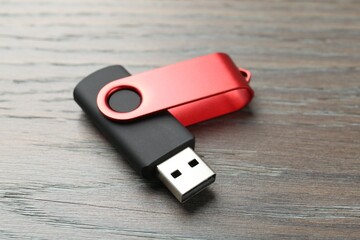 One flash drive on wooden background, closeup