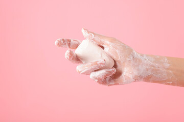 Fototapeta premium Woman washing hands with soap on light pink background, closeup