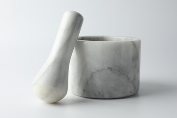 Marble mortar with pestle on white background, closeup